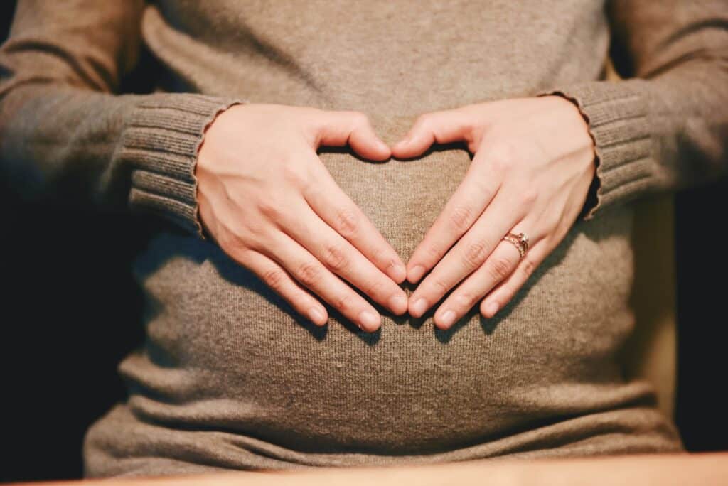 Žena sa srcem na stomaku koje podseća da selidba u trudnoći mora biti bezbedna